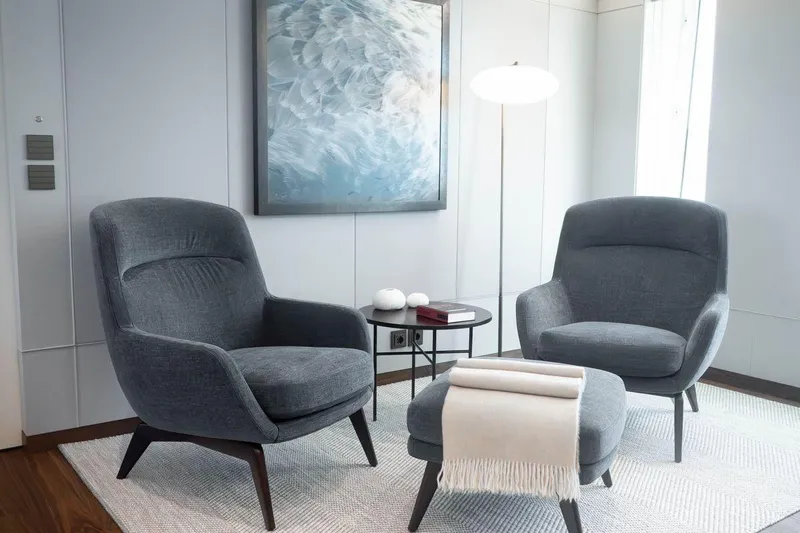 Blade II Yacht Photos Pics Modern living room with gray armchairs, ottoman, and abstract artwork.