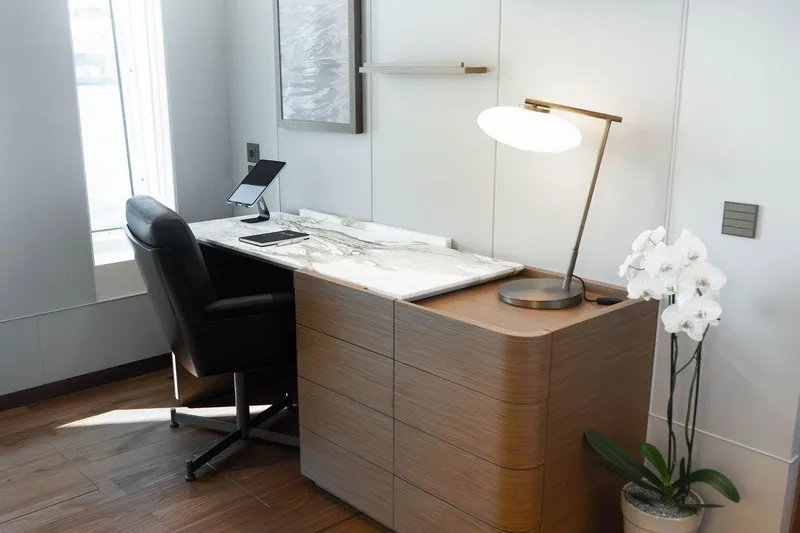 Blade II Yacht Photos Pics Modern office desk with marble top, leather chair, lamp, and orchid plant.