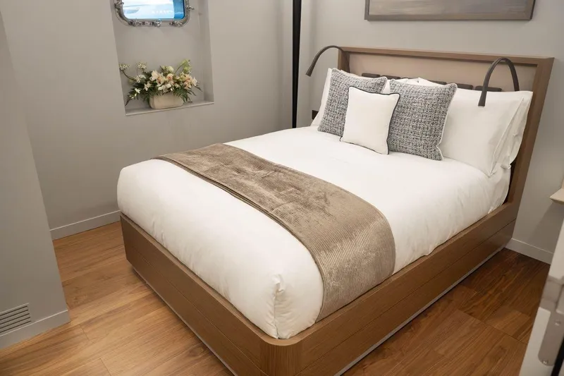 Blade II Yacht Photos Pics Cozy bedroom with modern decor, featuring a neatly made bed and elegant floral arrangement.