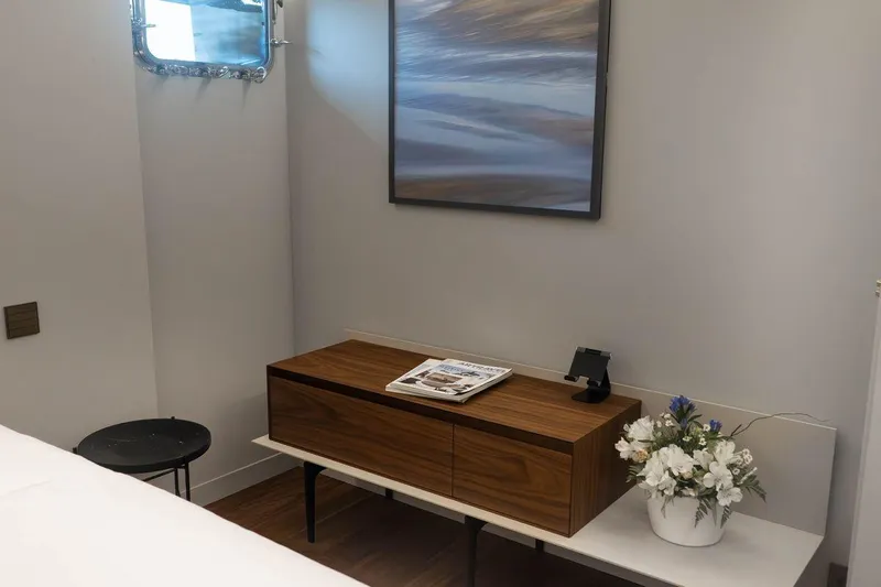 Blade II Yacht Photos Pics Modern interior with wooden cabinet, abstract art, and floral arrangement on MMGI BLADE II yacht.