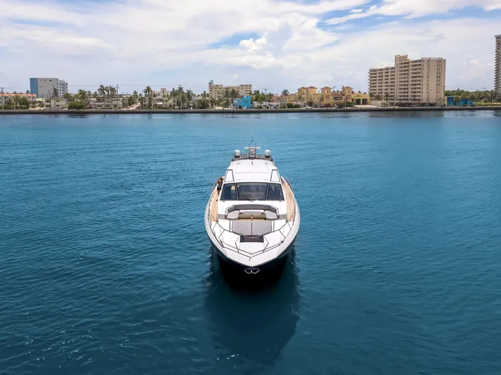 Bikinis Optional Yacht Photos Pics Luxury 2012 Cheoy Lee 76 Alpha yacht on calm blue water, cityscape in background.
