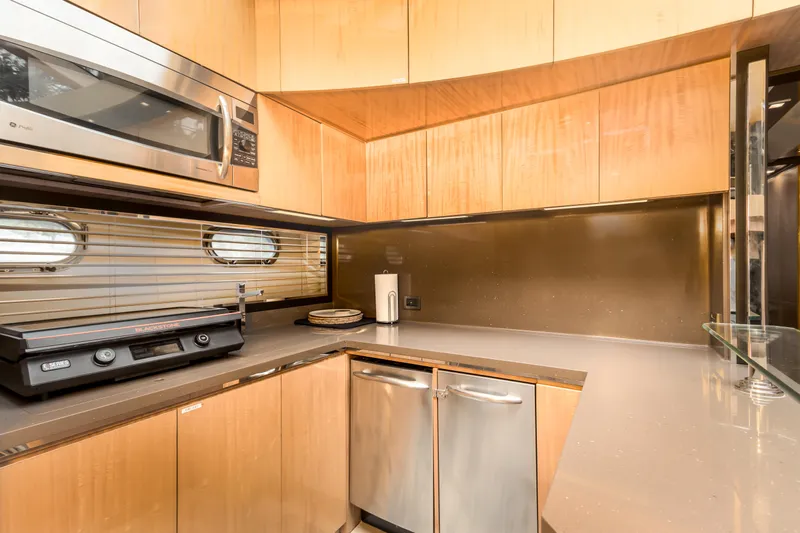 Bikinis Optional Yacht Photos Pics Modern kitchen interior of 2012 Cheoy Lee 76 Alpha yacht with wood cabinetry and stainless appliances.