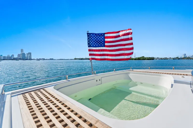 Bikinis Optional Yacht Photos Pics Luxury yacht Cheoy Lee 76 Alpha 2012 with American flag and jacuzzi, city skyline view.