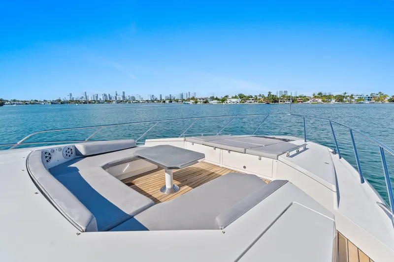 Bikinis Optional Yacht Photos Pics Luxurious 2012 Cheoy Lee 76 Alpha yacht deck with seating, overlooking serene waters and city skyline.