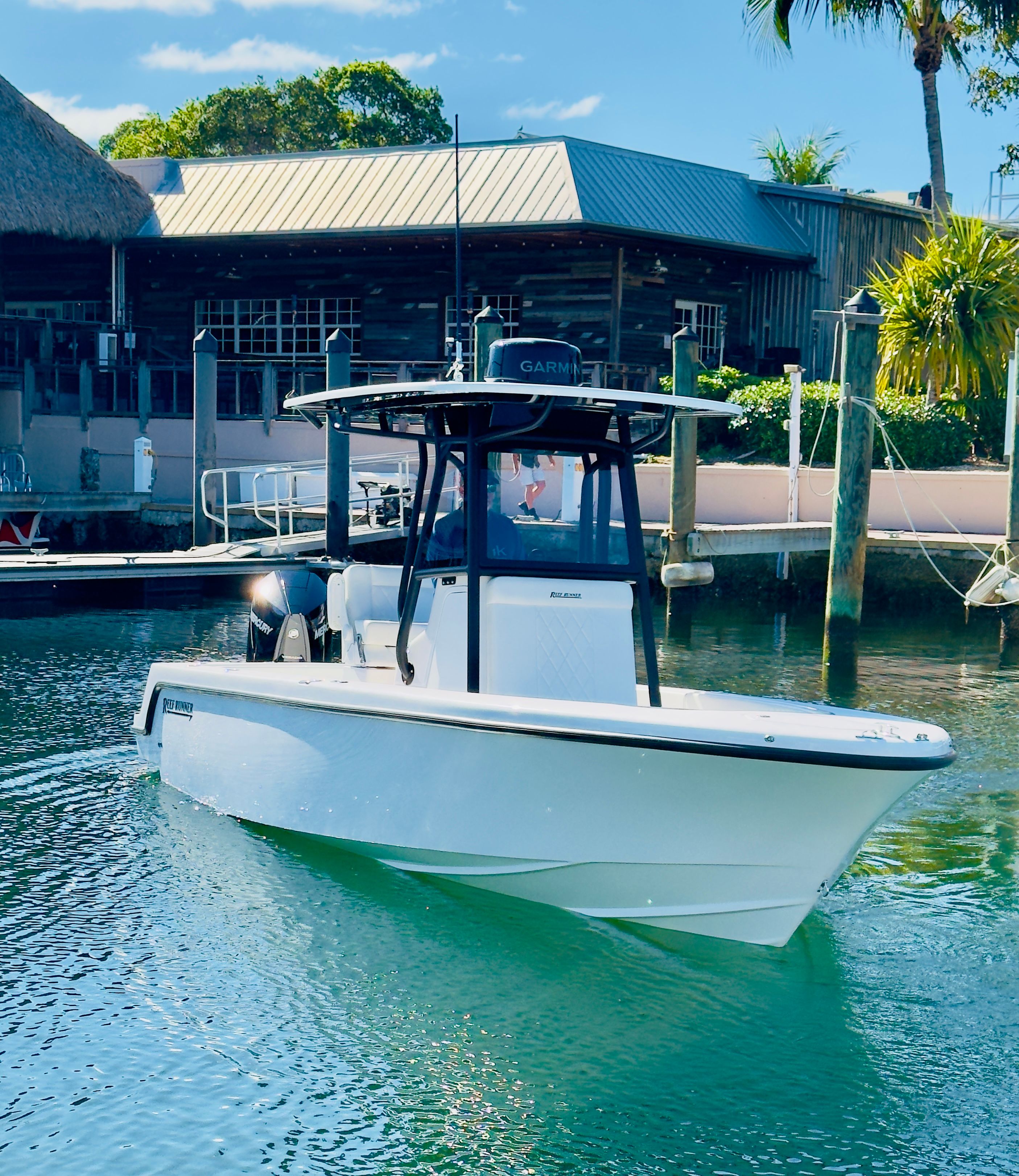 Reef Runner 230 C Open 2026 boat in water near a dock.