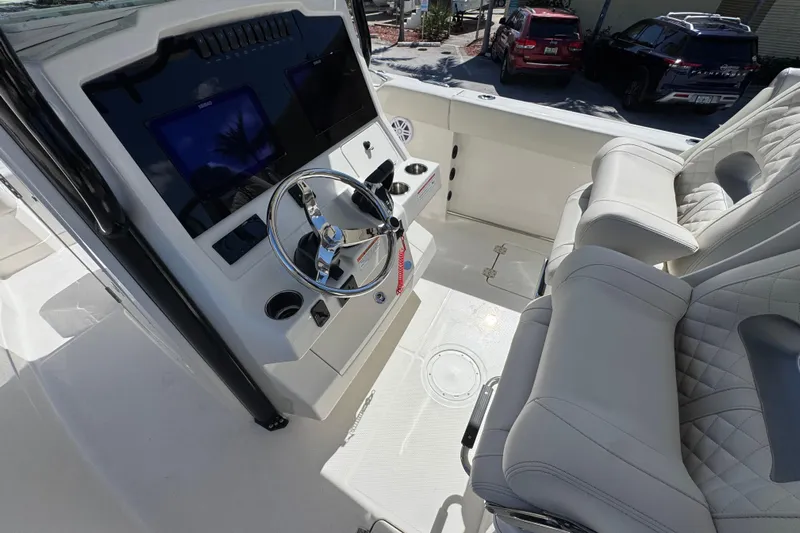  Yacht Photos Pics 2026 Sailfish 272 CC boat interior with steering wheel and plush seating.