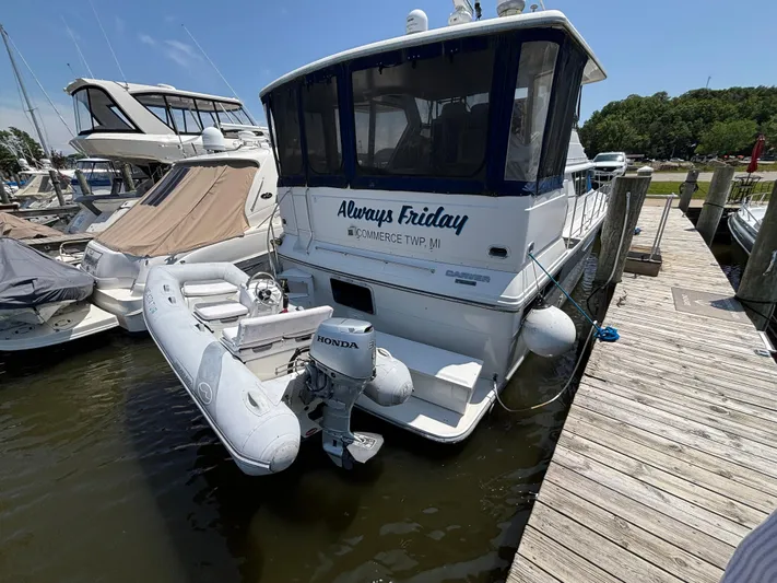  Yacht Photos Pics 1993 Carver 440 Aft Cabin Motor Yacht docked with inflatable boat attached.
