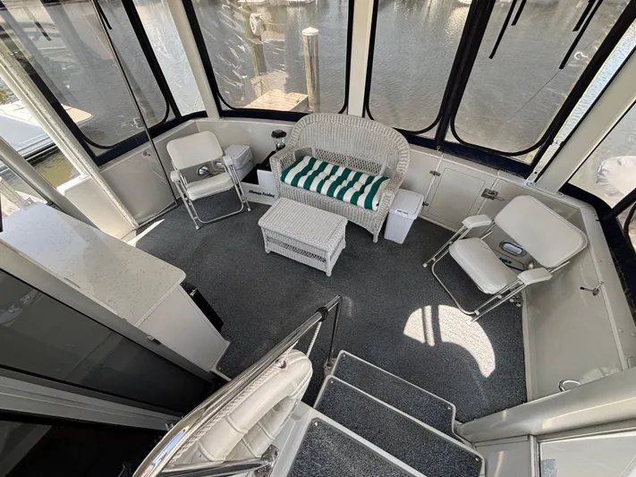  Yacht Photos Pics 1993 Carver 440 Aft Cabin Motor Yacht interior with seating and table, featuring large windows.