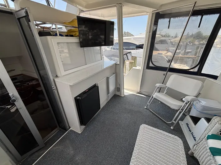  Yacht Photos Pics 1993 Carver 440 Aft Cabin Motor Yacht interior with seating, TV, and windows.