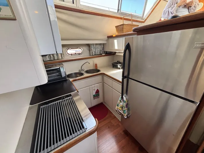  Yacht Photos Pics 1993 Carver 440 Aft Cabin Motor Yacht kitchen with stainless steel appliances and wooden flooring.