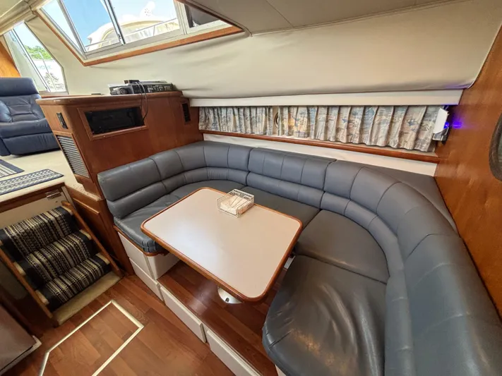  Yacht Photos Pics 1993 Carver 440 Aft Cabin Motor Yacht interior with curved seating and table.