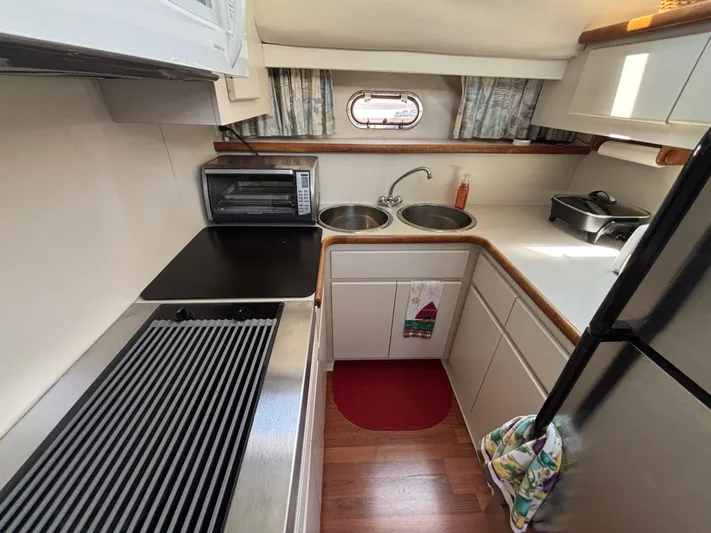  Yacht Photos Pics 1993 Carver 440 Aft Cabin Motor Yacht kitchen with stove, sink, and appliances.