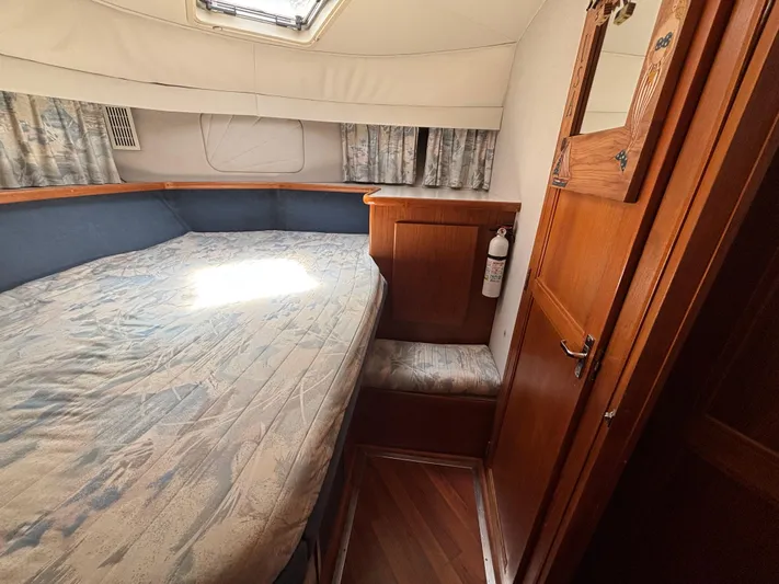  Yacht Photos Pics 1993 Carver 440 Aft Cabin Motor Yacht interior with bed, wooden cabinetry, and natural light.