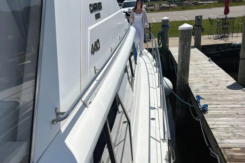  Yacht Photos Pics 1993 Carver 440 Aft Cabin Motor Yacht docked with person on deck.