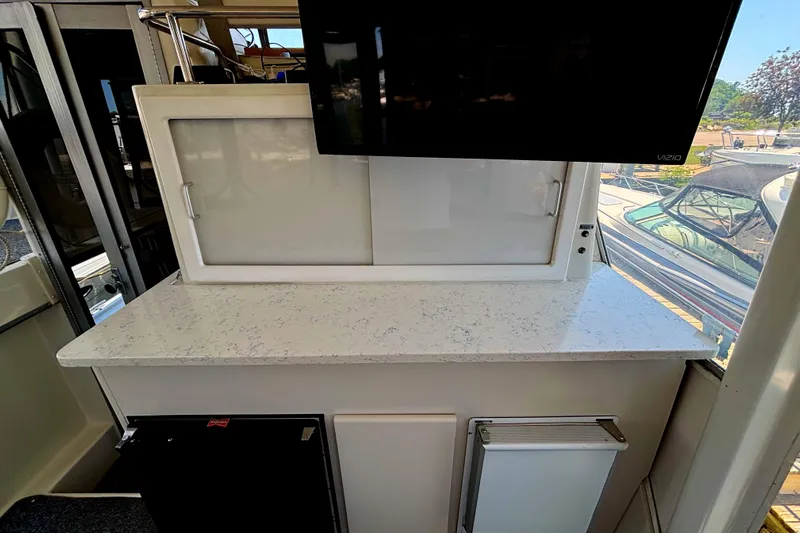  Yacht Photos Pics 1993 Carver 440 Aft Cabin Motor Yacht interior with countertop and mounted TV.