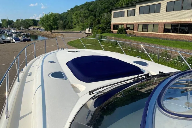  Yacht Photos Pics 1998 Sunseeker Predator 58 yacht docked near a marina with lush greenery.