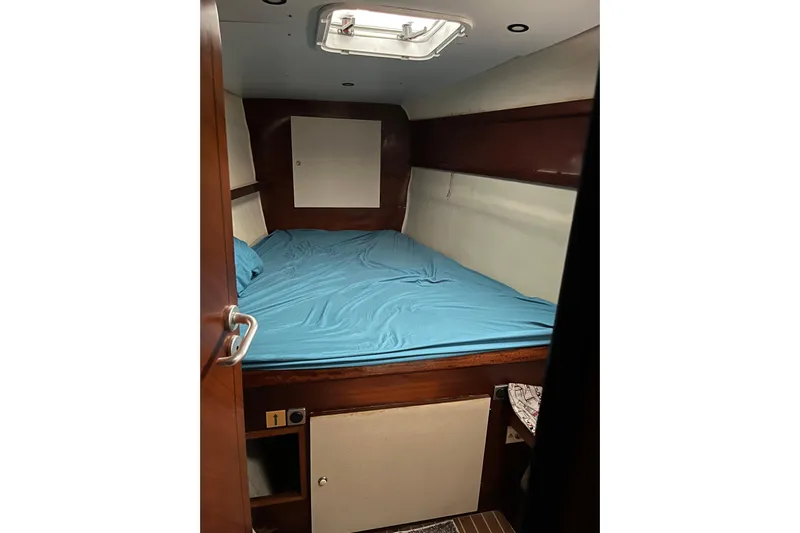 Nikita 1 Yacht Photos Pics Cabin interior of 2004 Fountaine Pajot Bahia 46 with blue bedding and wooden accents.