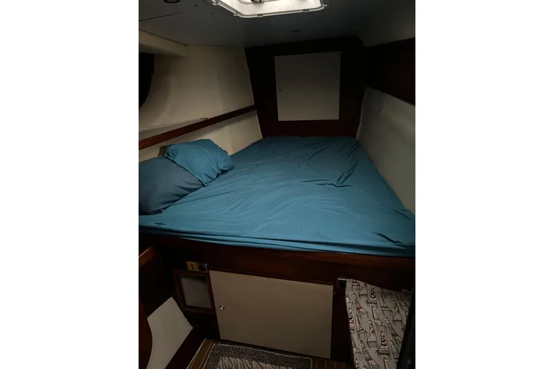 Nikita 1 Yacht Photos Pics 2004 Fountaine Pajot Bahia 46 cabin with blue bedding and wooden accents.
