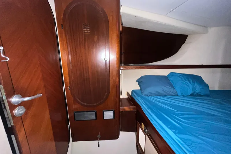 Nikita 1 Yacht Photos Pics 2004 Fountaine Pajot Bahia 46 cabin interior with wooden door and blue bedding.