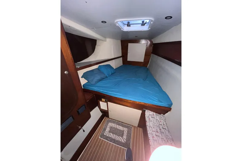 Nikita 1 Yacht Photos Pics Cozy cabin interior of 2004 Fountaine Pajot Bahia 46 with blue bedding.