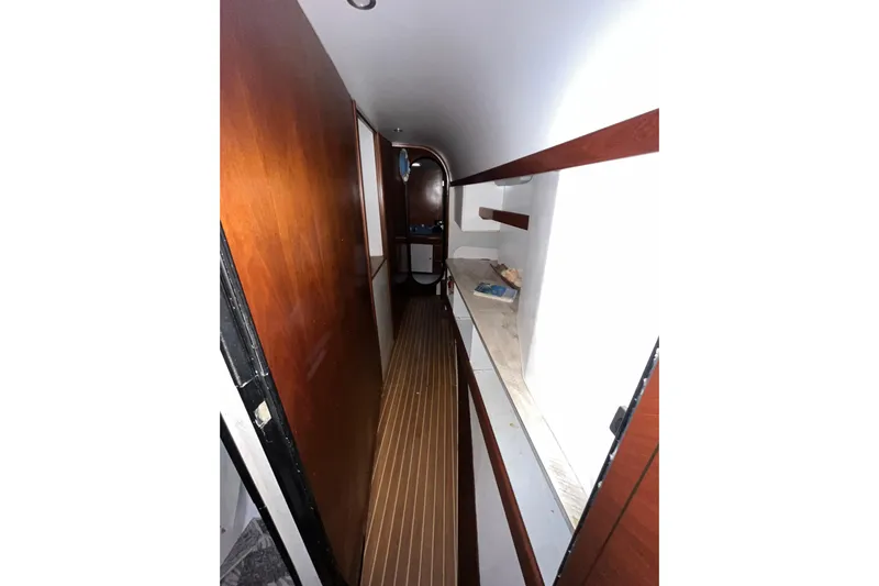 Nikita 1 Yacht Photos Pics Narrow hallway inside 2004 Fountaine Pajot Bahia 46 catamaran, featuring wooden paneling and flooring.