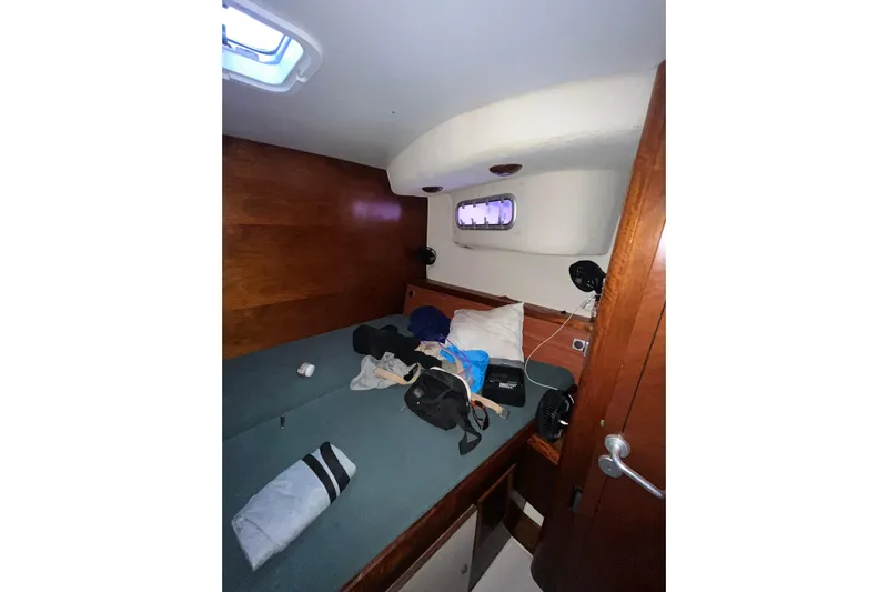 Nikita 1 Yacht Photos Pics Cozy cabin interior of 2004 Fountaine Pajot Bahia 46 catamaran with wooden paneling and porthole.