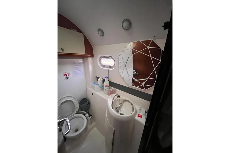 Nikita 1 Yacht Photos Pics Bathroom interior of 2004 Fountaine Pajot Bahia 46 catamaran, featuring toilet, sink, and geometric mirror.