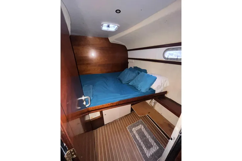 Nikita 1 Yacht Photos Pics Cozy cabin interior of 2004 Fountaine Pajot Bahia 46 with blue bedding and wooden accents.