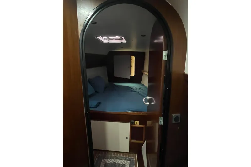 Nikita 1 Yacht Photos Pics Cabin interior of 2004 Fountaine Pajot Bahia 46 catamaran with cozy bed and wooden finish.