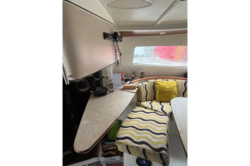 Nikita 1 Yacht Photos Pics Interior of 2004 Fountaine Pajot Bahia 46 with patterned seating and communication equipment.