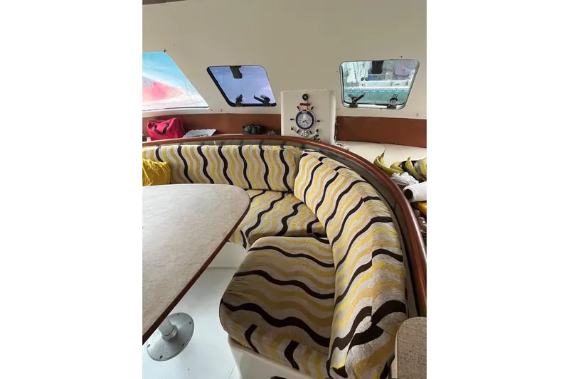 Nikita 1 Yacht Photos Pics Interior of 2004 Fountaine Pajot Bahia 46 with patterned seating and dining area.