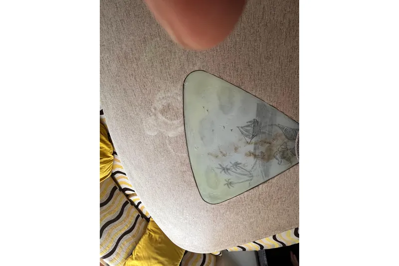 Nikita 1 Yacht Photos Pics Interior of 2004 Fountaine Pajot Bahia 46 with decorative table and striped cushions.