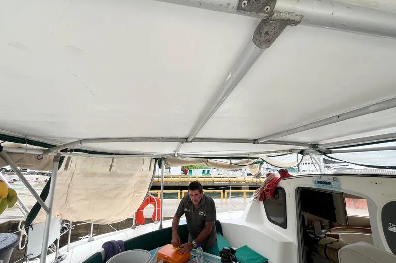 Nikita 1 Yacht Photos Pics 2004 Fountaine Pajot Bahia 46 catamaran interior with person preparing equipment.