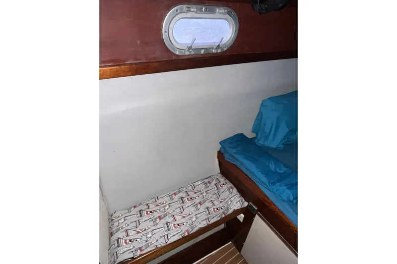 Nikita 1 Yacht Photos Pics Cabin interior of 2004 Fountaine Pajot Bahia 46 with bedding and porthole.