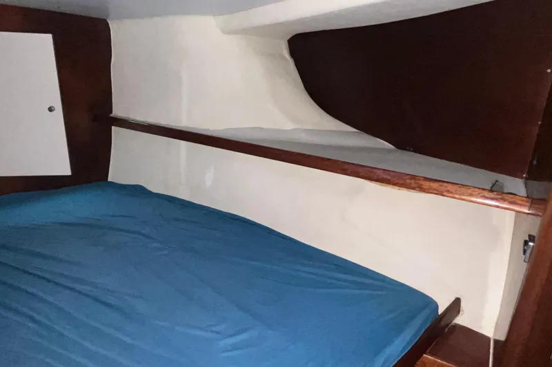 Nikita 1 Yacht Photos Pics Interior cabin of 2004 Fountaine Pajot Bahia 46 with blue bedding and wooden accents.