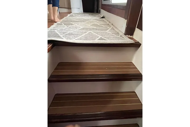 Nikita 1 Yacht Photos Pics Interior stairs of 2004 Fountaine Pajot Bahia 46 catamaran with wooden steps and carpet.