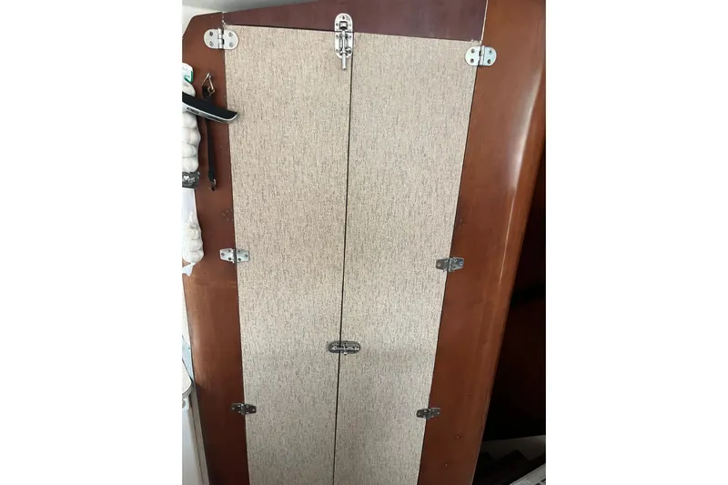 Nikita 1 Yacht Photos Pics Cabinet door inside 2004 Fountaine Pajot Bahia 46 catamaran, featuring wooden finish and metal hinges.