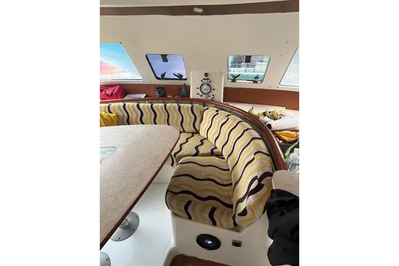 Nikita 1 Yacht Photos Pics Interior of 2004 Fountaine Pajot Bahia 46 with striped seating and dining area.