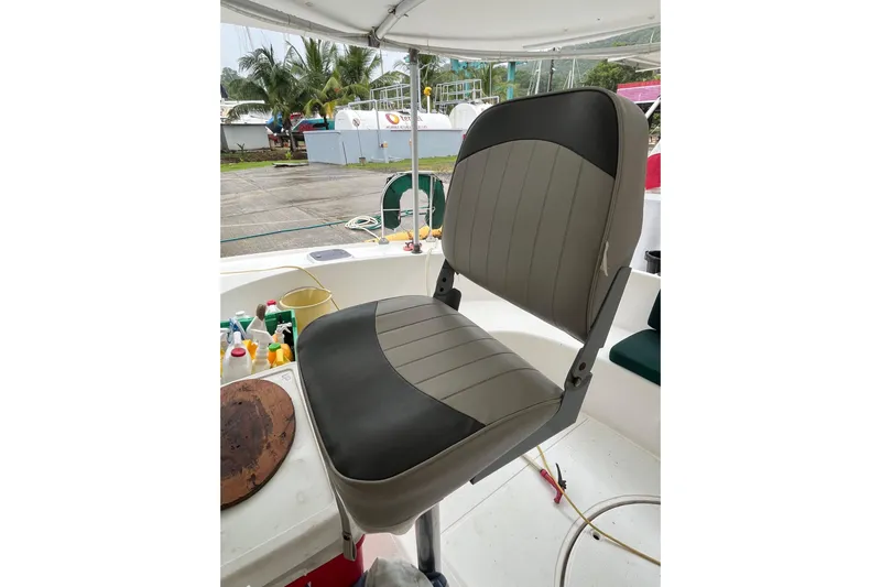 Nikita 1 Yacht Photos Pics Captain's chair on 2004 Fountaine Pajot Bahia 46 catamaran, docked with palm trees in background.