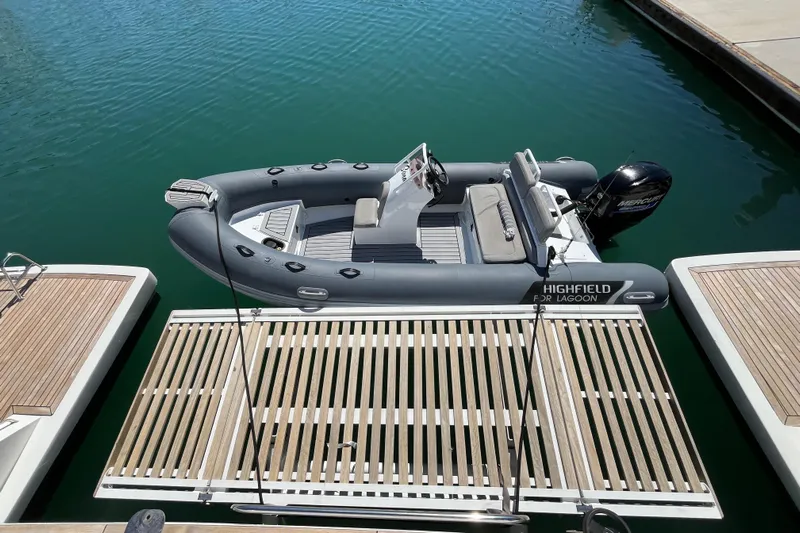 Sona 1 Yacht Photos Pics RIB boat docked beside Lagoon 630 Motor Yacht, 2019 model, in a marina.