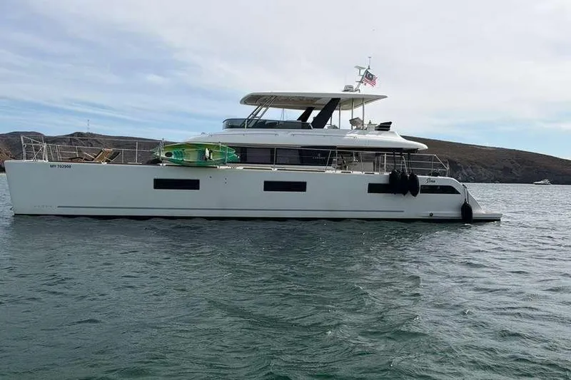 Sona 1 Yacht Photos Pics 2019 Lagoon 630 MY yacht anchored in calm waters, with scenic coastal backdrop.