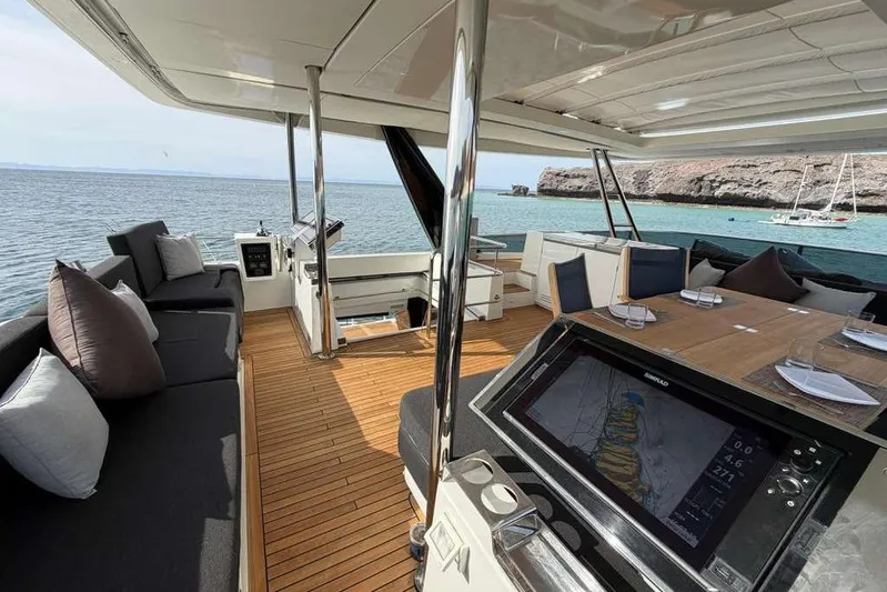 Sona 1 Yacht Photos Pics Luxurious 2019 Lagoon 630 MY yacht interior with ocean view, featuring elegant seating and navigation display.