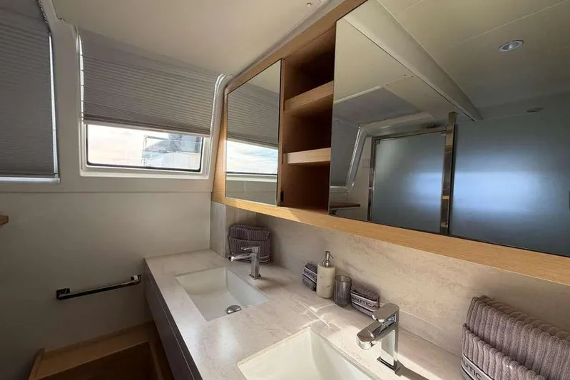 Sona 1 Yacht Photos Pics Luxurious bathroom interior of 2019 Lagoon 630 MY yacht with dual sinks and modern fixtures.