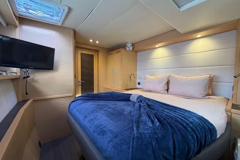 Sona 1 Yacht Photos Pics Luxurious cabin interior of 2019 Lagoon 630 MY yacht with cozy bed and TV.