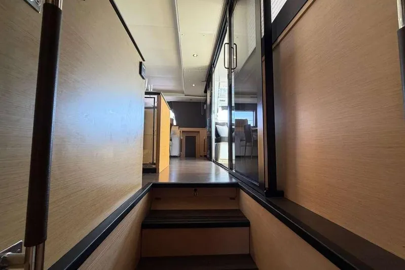 Sona 1 Yacht Photos Pics Interior view of 2019 Lagoon 630 MY yacht, featuring modern wood paneling and glass doors.