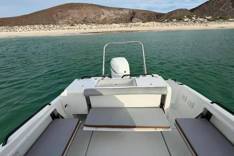 Sona 1 Yacht Photos Pics Lagoon 630 MY 2019 yacht on serene water near a sandy beach and rocky hills.