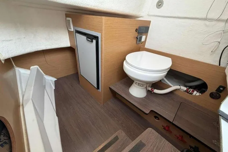 Sona 1 Yacht Photos Pics Interior of 2019 Lagoon 630 MY yacht featuring a compact bathroom with toilet and mini fridge.