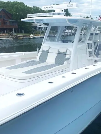  Yacht Photos Pics 2023 Invincible 46 Catamaran with Quad Axle Trailer, docked near waterfront homes.