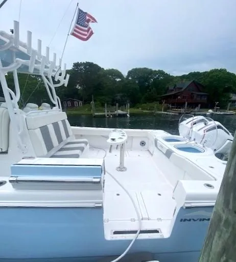  Yacht Photos Pics 2023 Invincible 46 Catamaran with Quad Axle Trailer, docked, featuring spacious seating and American flag.