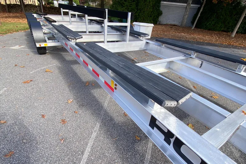  Yacht Photos Pics 2023 Invincible 46 Catamaran Plus Quad Axle Trailer, sturdy design, parked outdoors.